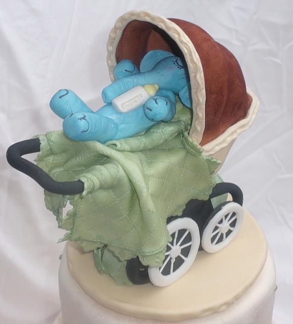 Old fashioned or old time baby carriage with blue gumpaste baby elephant side view