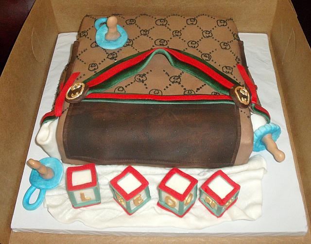 Gucci Baby Diaper Bag Cake With Edible Baby Blocks, Pacifiers, Baby Bottle top view
