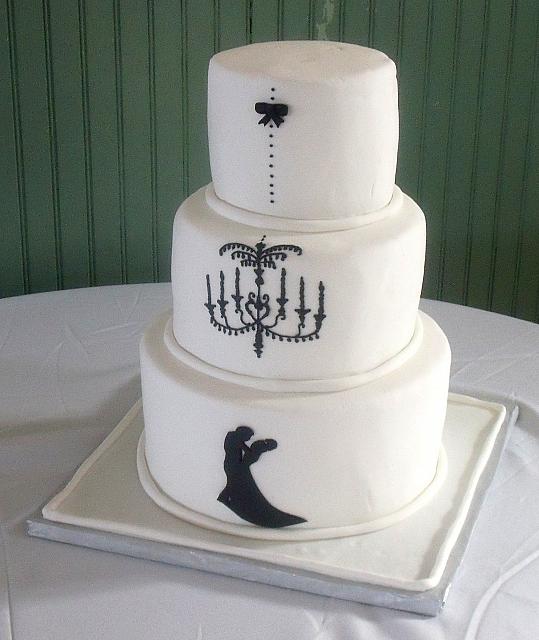 White fondant covered Wedding Cake with dancing couple silhouette cut out of gumpaste under royal icing decorated chandelier Main View