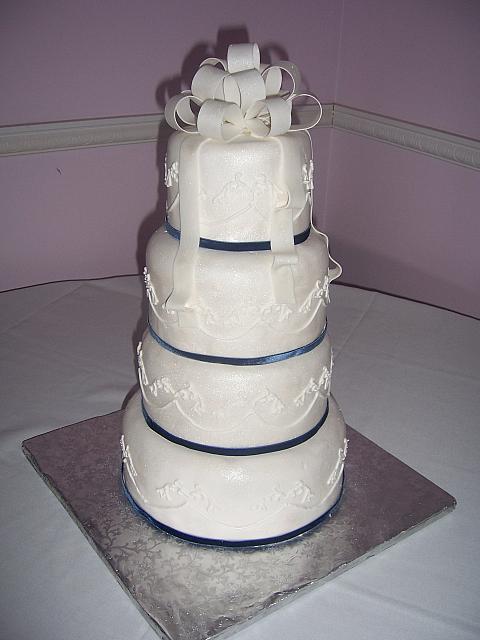 Simple white wedding cake with edible gumpaste bow on top