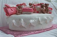 Side view of baby shower cake with edible bears, presents, and purse