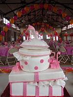 Quinceanera Cake in Pink and White with Stacked Presents, Edible Fashion Shoe, Pillow, and Princess Crown view onto party room