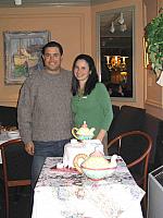 Engaged couple next to their bridal shower cake